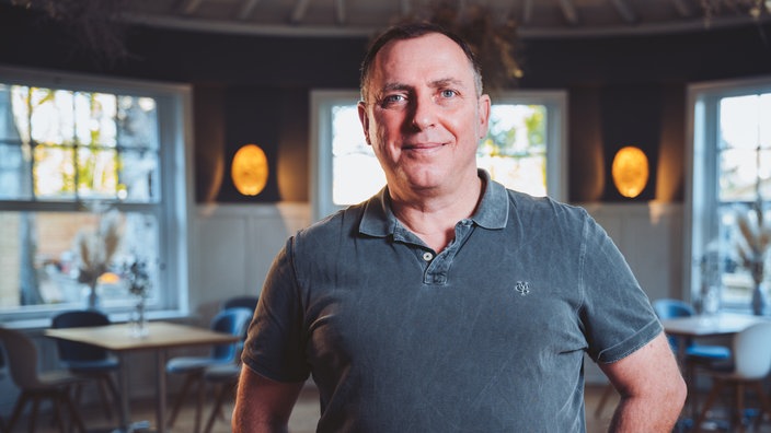 Ciro Colella steht in einem Lokal.