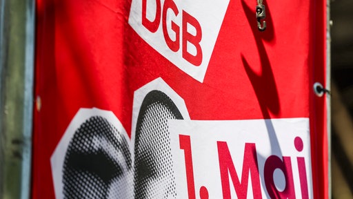 Eine Fahne vom DGB zum 1. Mai hängt an der Bühne in Siegburg