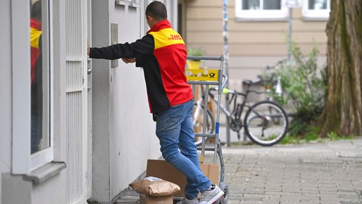 DHL Paketzusteller wartet vor der Haustür
