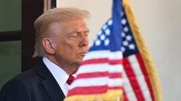 US-Präsident Donald Trump mit einer Amerikanischen Flagge im Vordergrund