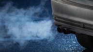 Silbernes Auto mit auffälligem Auspuffrauch