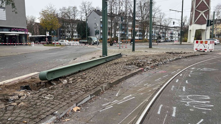 Ein Mast liegt umgekippt auf dem Kopfsteinpflaster