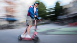 Ein Mann fährt auf einem E-Scooter