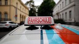 Ein Schild 'Fahrschule' auf einem Fahrschul-Auto