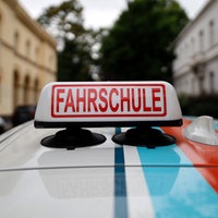 Ein Schild 'Fahrschule' auf einem Fahrschul-Auto