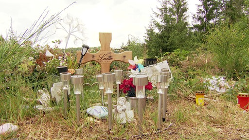 Ein Kreuz und Kerzen in Gedenken an Luise.