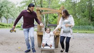 Eltern spielen mit ihren Kindern auf einem Spielplatz