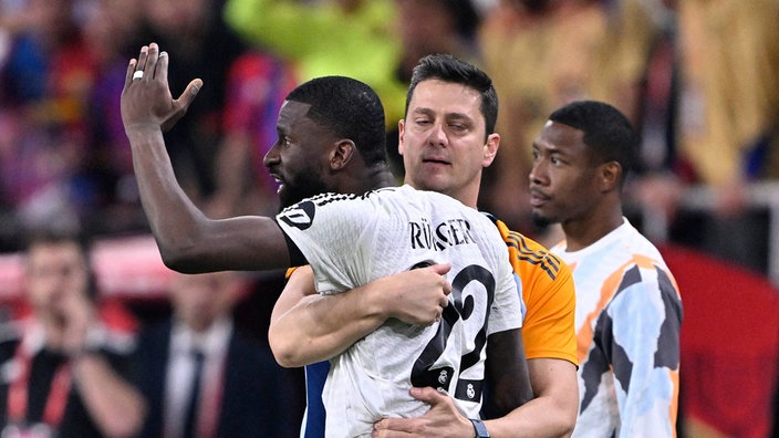 Gegenerischer Spieler hält Antonio Rüdiger