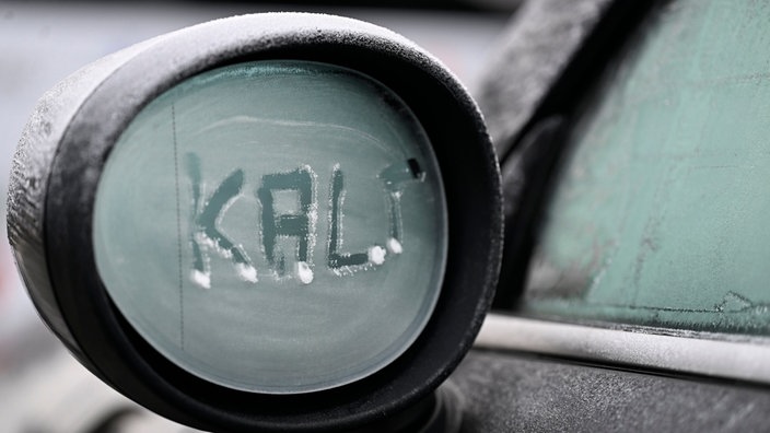 Auf den eingefrorenen Außenspiegel eines Autos wurde das Wort "kalt" geschrieben