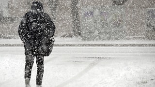 Ein Fußgänger geht durch den Schnee