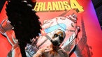Ein Cosplayer posiert vor einem Plakat von Borderlands 4.