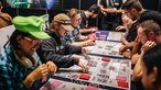 Besucher spielen ein Kartenspiel bei der Gamescom