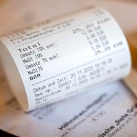 Eine Rechnung mit Umsatzsteuer und Mehrwertsteuer liegt auf der Speisekarte eines Restaurants