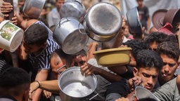 Palästinenser stehen mit Kochtöpfen im Norden Gazas an einer Charity-Küche an