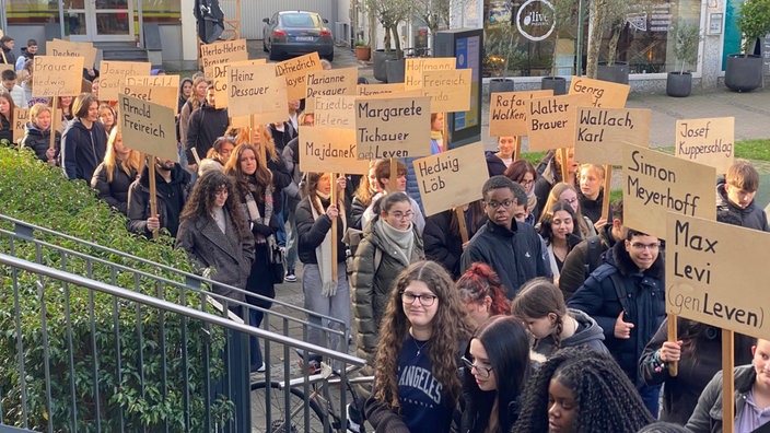 Schüler gedanken mit Schildern an die Progromnacht 