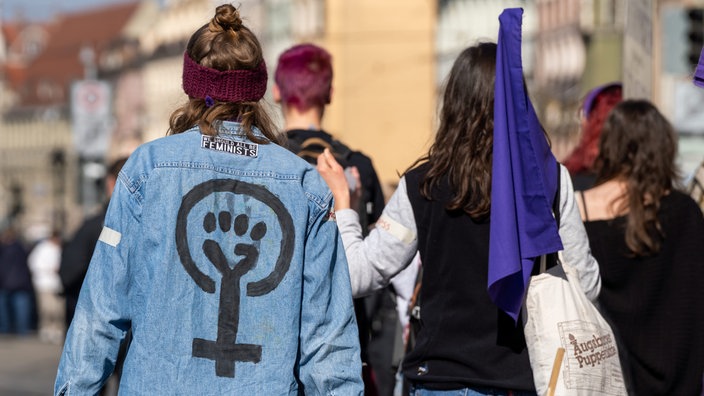  Frau trägt Kleidung mit Feminismus Symbol und geballter Faust