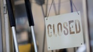 Ein Schild mit der Aufschrift "closed" (geschlossen) hängt am Eingang eines Geschäftes in Köln.