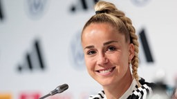 Fußballerin Giulia Gwinn lächelt bei einer Pressekonferenz zur Fußball-EM 2025.