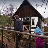 Ein Mann und zwei Mädchen laufen auf ein Fachwerkhaus zu