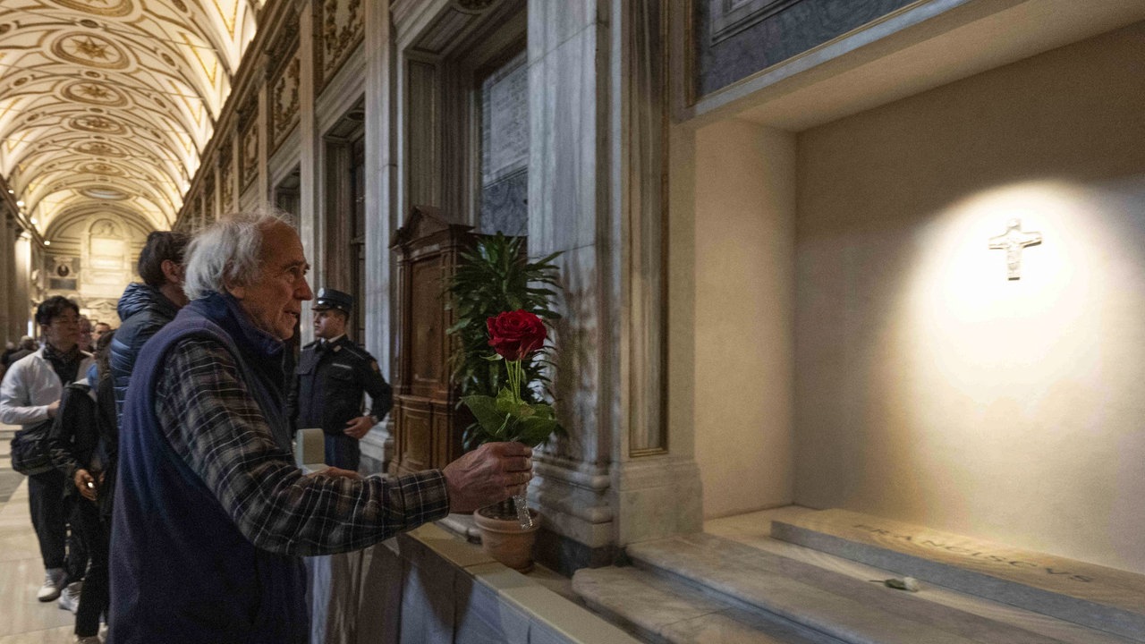 Ein alter Mann mit Blumen vor dem Grab Papst Franziskus'