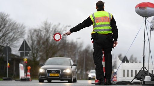 Grenzpolizist winkt ein Auto mit einer Kelle heraus