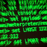 Buchstaben und Zahlen leuchten auf einem Bildschirm, auf dem ein Hacker-Programm geöffnet ist