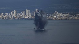 Ein Geschoss explodiert über dem Wasser in der Bucht von Haifa, Israel