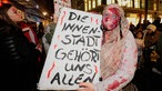Person verkleidet als Zombie hält ein Schild mit der Aufschrift:  "Die Innenstadt gehört uns allen" 