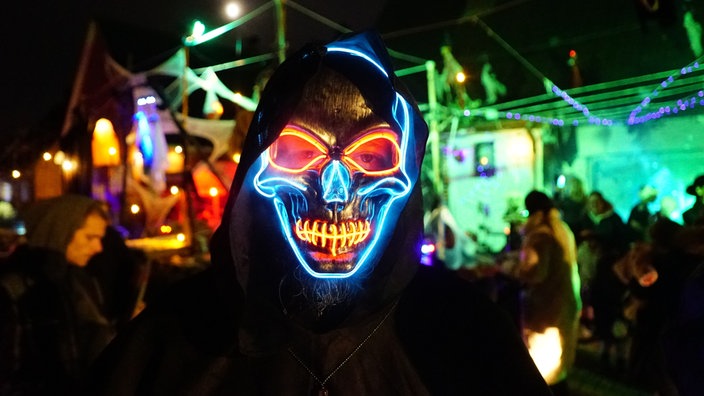 Person mit leuchtender Skelettmaske