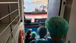  Personen in Schutzbekleidung werden von dem vom Hantavirus befallenen Kreuzfahrtschiff "MV Hondius" ausgeschifft
