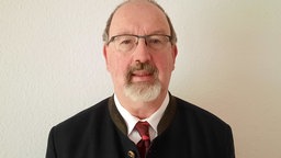 Ein Mann mit Brille und Bart blickt in die Kamera