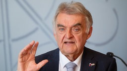 Herbert Reul (CDU), Innenminister von Nordrhein-Westfalen, sitzt bei einer Pressekonferenz zur Vorstellung des NRW Verfassungsschutzberichts 2025 auf dem Podium.