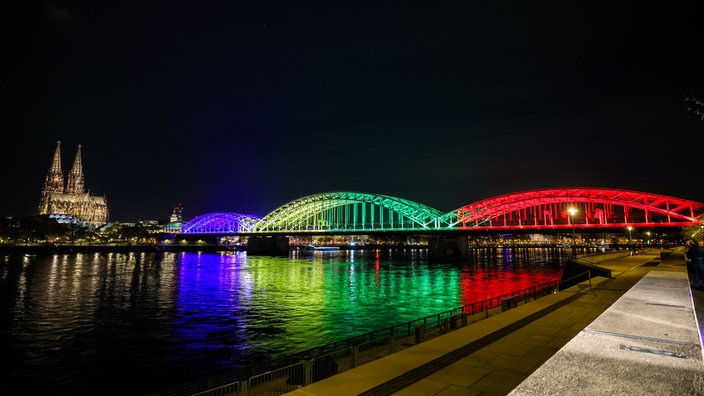 Die Hohenzollernbrücke leuchtet in den olympischen Farben nach der erfolgreichen Abstimmung um die Olympischen Spiele in Nordrhein-Westfalen.