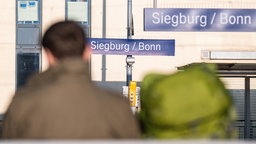 Ein Mann sitzt auf einer Bank am Bahnhof Siegburg