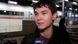 Person steht vor einem ICE am Bahnhof