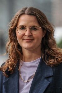 Porträt-Aufnahme von Isabel Schneider. Sie lächelt in Richtung der Kamera.