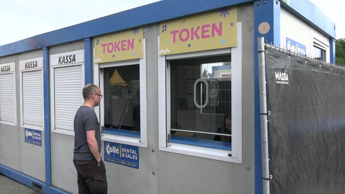 Eine Person steht vor Tokenstand