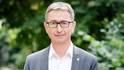 Mann mit Brille schaut in die Kamera