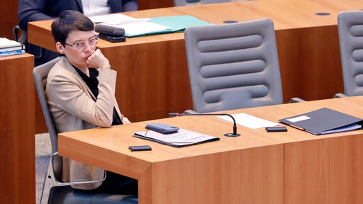 Josefine Paul sitzt alleine in einer Parlamentsbank im NRW-Landtag