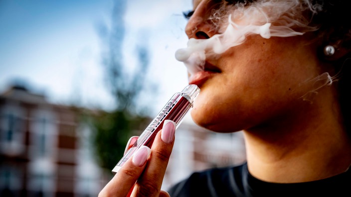 Eine junge Frau benutzt ihre Vape