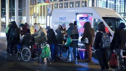 Menschen stehen vor einem Kältebus