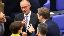 Saskia Esken, Friedrich Merz und Lars Klingbeil unterhalten sich 