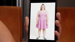 Bild von einer Frau mit rosa Kleid auf einem Handydisplay