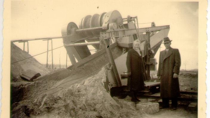 Helene und Sohn Wilhelm Süß neben einem Kiesbagger in Langenfeld im Jahr 1953