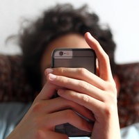 Ein junger Mann blickt auf ein Smartphone