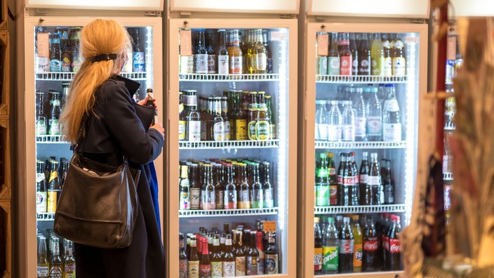 Eine Frau holt sich ein Getränk aus einem Kühlschrank im Kiosk Casablanca in Köln-Sülz