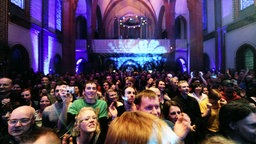 Konzertbesucher in einem Kirchenschiff