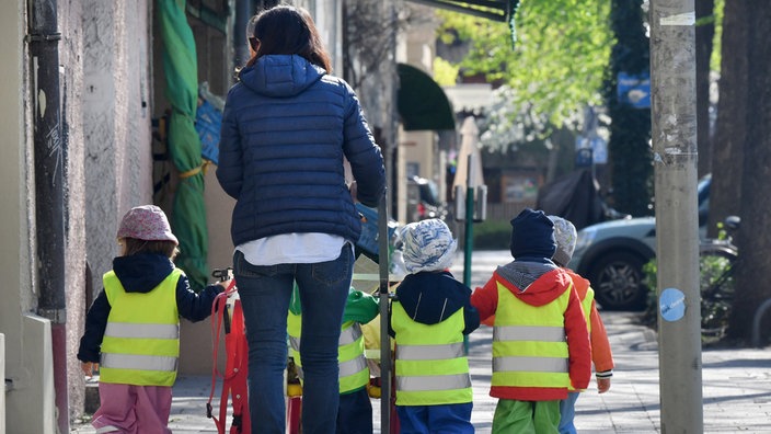 Eine Erzierhin ist mit fünf Kindern auf einem Ausflug