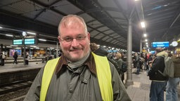 Ein Mann steht an einem Gleis des Bonner Hauptbahnhofs.