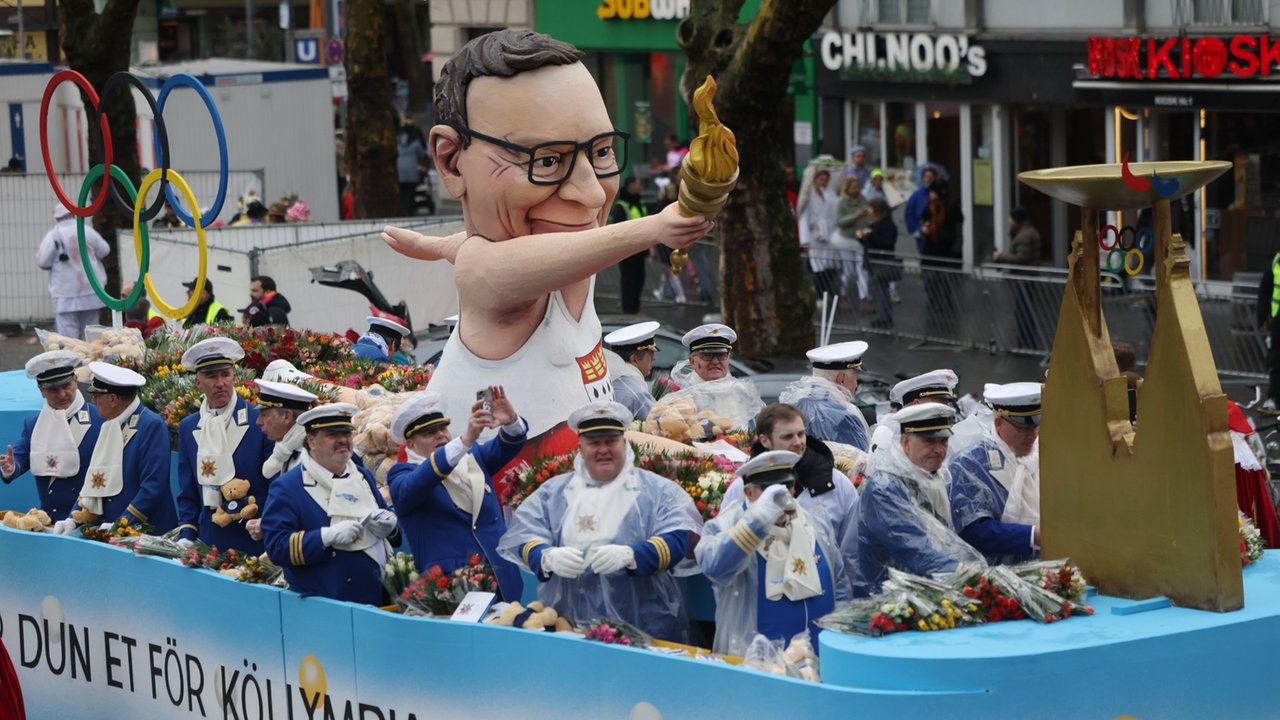 Motivwagen mit dem Oberbürgermeister mit dem Olympischen Feuer nimmt am Rosenmontagszug in Köln teil